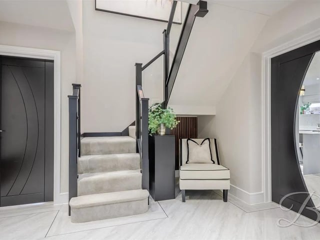 Enter a bright entrance hallway with soft neutral tones, fitted cloakroom, high ceilings and quality finishes.