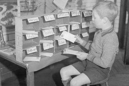 A young letter sorter at work at King Edward Infants School's miniature post office in 1935. The school still exists today, but as part of a combined institution called King Edward Primary School and Nursery. The infant and junior departments were merged and restructured over time to form the current primary school.
