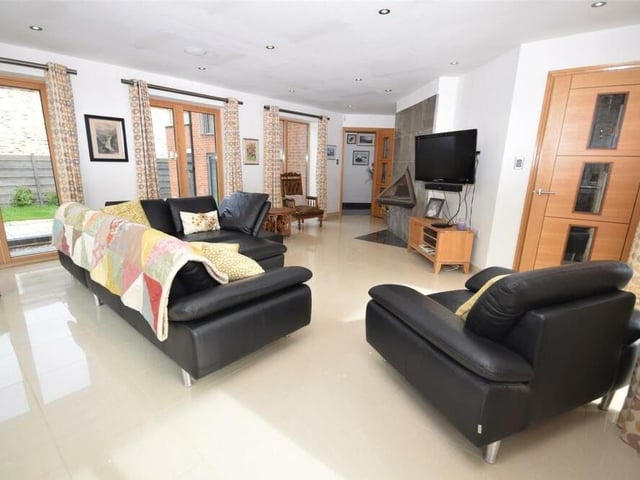 Among the other eyecatchjng features of the lounge are a bespoke, wall-mounted log-burning fire prism, on-trend, polished tiled flooring, underfloor heating and cosy downlighting to the ceiling, adding an atmospheric air.