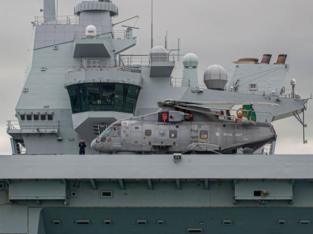 HMS Queen Elizabeth pictured with a Merlin helicopter on her flight deck as she departed Portsmouth on September 9. Picture: Habibur Rahman