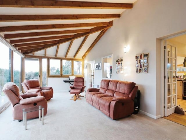 Leading directly from the living room is this brilliant sun room, which is flooded with natural light. Ceiling beams add to its character, while extensive windows and doors give perfect views of, or lead outside to, the garden.