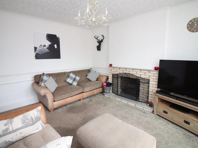 A close-up of the lounge shows the open fireplace. Imagine cold winter nights in front of the fire and the TV.