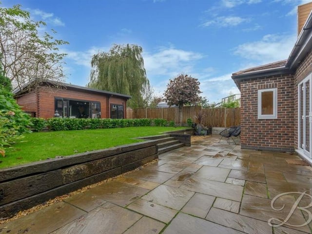 It was raining when the photo was taken, but this patio seating area, with steps leading up to the lawn, is a lovely spot in the rear garden to relax in good weather.