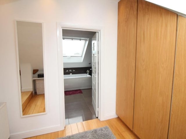 Next to the en suite bathroom in the main bedroom on the second floor is this dressing area.A sizeable space, it has fitted wardrobes and ceiling spotlights.