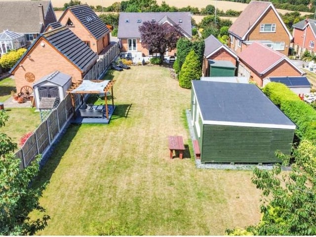 Our photo gallery now switches to the exterior of the bungalow. This is good aerial shot of the extensive back garden, with its lengthy lawn and 'man cave' on the right.