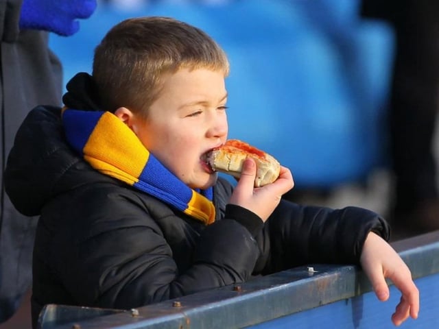 A young fan tucks in before the match.