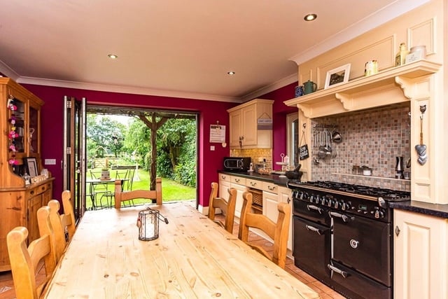 The hand painted kitchen provides "ample" worktop space and aga style oven and stove. Folding full length doors open to the front garden with lawn, apple trees and views out across the paddocks.