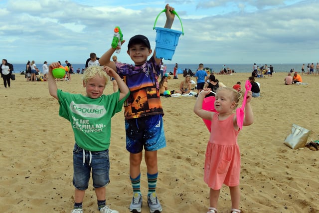 Youngsters Carter Nicholson, four, Jake Flaherty, eight and Isabell Nicholson, two have fun with their buckets and spades.