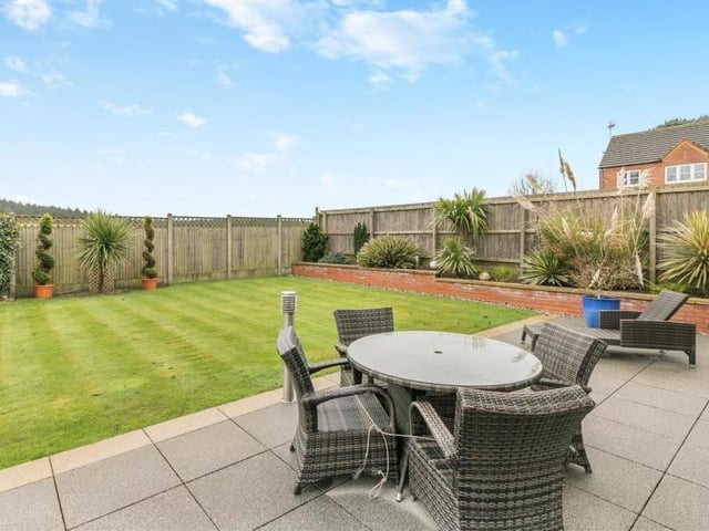It's not hard to imagine lazy summer days with family or friends, relaxing on the patio as the sun beats down on the lawn. There are gravel borders to each side of the lawn, with a low, retaining walled boundary and raised beds featuring mature plants and shrubs.