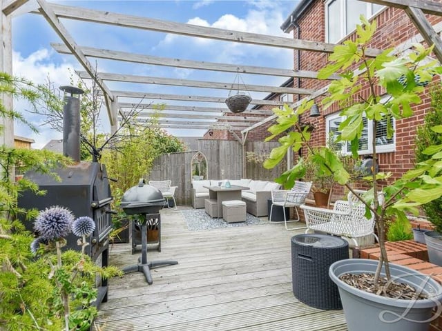 It's about time we stepped outside to take a look at the property's lovely garden. It includes this decked seating area, which is perfect for barbecues and gatherings with family and friends.