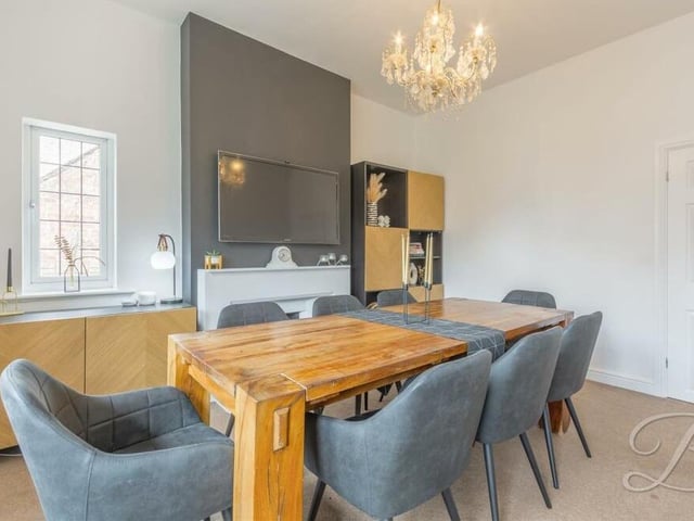 The dining room from a different angle, showing another feature fireplace and a carpeted floor.