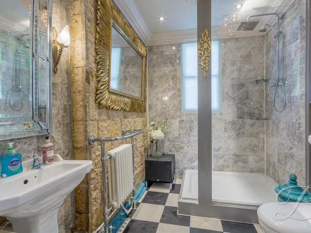 Next to the downstairs bedroom is this luxurious shower room, which includes walk-in shower cubicle with overhead waterfall shower, wash hand basin, low-flush WC and downlights.