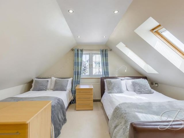On the first floor of the detached annexe is this bedroom, with carpeted flooring, downlights and two Velux windows.