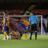 Mansfield Town midfielder Anthony Hartigan picks up an injury during the Papa John's Trophy match against Grimsby Town.