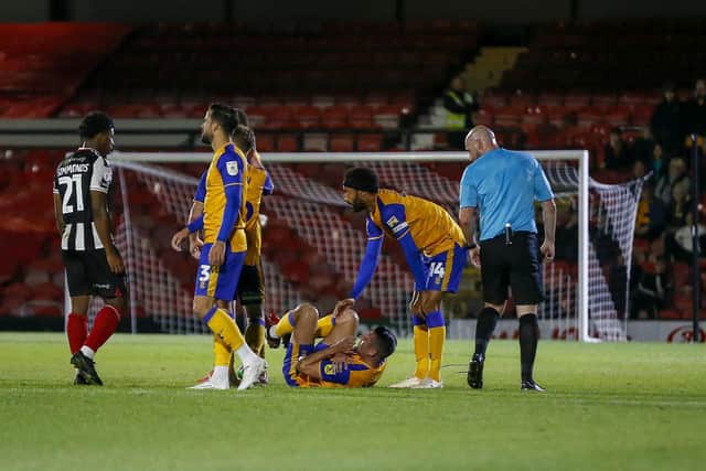 Mansfield Town midfielder Anthony Hartigan picks up an injury during the Papa John's Trophy match against Grimsby Town.