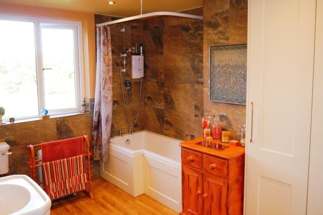 As we move up to the first floor at the Turnerwood cottage, the first room we come across is this neat bathroom. It is fitted with a three-piece suite comprising a panelled bath, with independent electric shower over, pedestal wash hand basin and low-level WC.