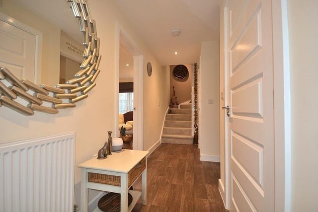 Leading the way into the spacious £365,000 Kirkby house is this inviting entrance hall. It has three LED ceiling spotlights, vinyl flooring and a built-in storage cupboard.