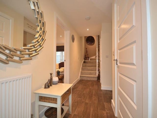 Leading the way into the spacious £365,000 Kirkby house is this inviting entrance hall. It has three LED ceiling spotlights, vinyl flooring and a built-in storage cupboard.