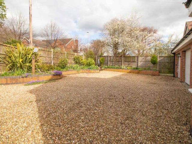 The gravelled driveway at the front of the house that provides space for off-street parking and leads to a double garage.