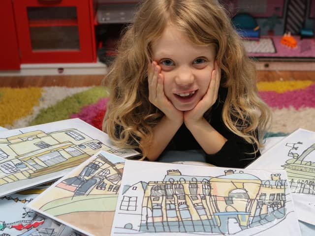 Chloe Daykin aged eight with some of her detailed pictures of some of Mansfield's landmarks. The little girl with autism and ADHD has developed her own unique style.