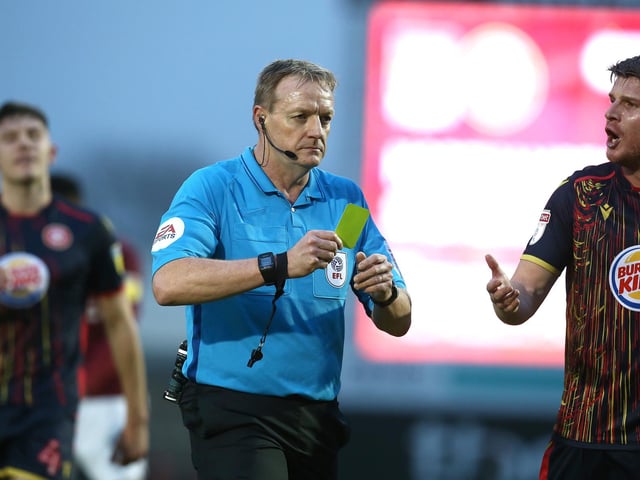 Referee Trevor Kettle prepares to show Elliott List a yellow card. Stevenage had 55 bookings and three red cards.
