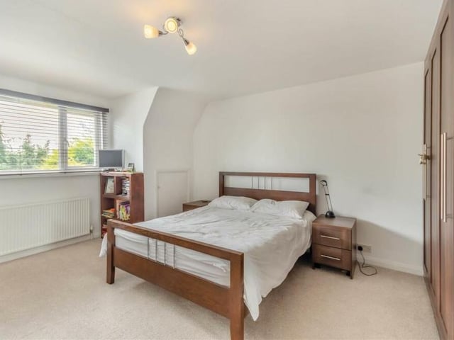 The second bedroom, which faces the back of the house, also features extensive fitted wardrobes, with rails and shelves.