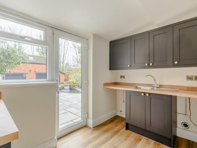 Off the kitchen/diner is this utility room, which has plumbing for a washing machine and space for a tumble dryer. Modern shaker-style cabinets, an inset stainless steel sink and doors to the front and side of the house add to its usefulness.