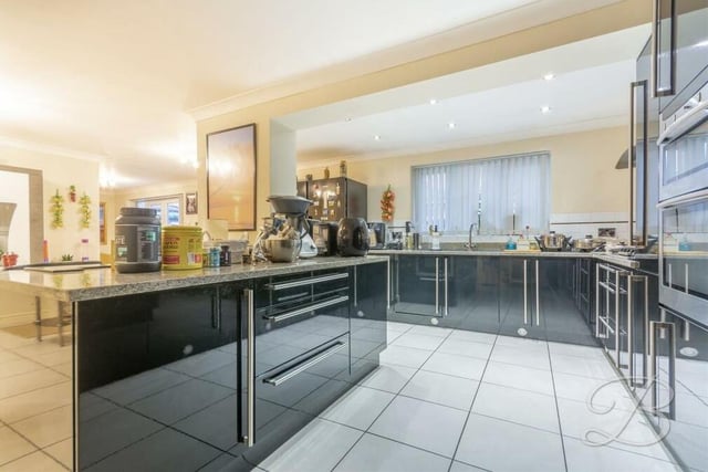 Moving into the open-plan kitchen'diner next. It comes complete with a breathtaking range of high-gloss black units with complementary worktops over, inset sink and drainer with mixer tap. A central island doubles up as a breakfast bar.