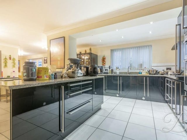Moving into the open-plan kitchen'diner next. It comes complete with a breathtaking range of high-gloss black units with complementary worktops over, inset sink and drainer with mixer tap. A central island doubles up as a breakfast bar.