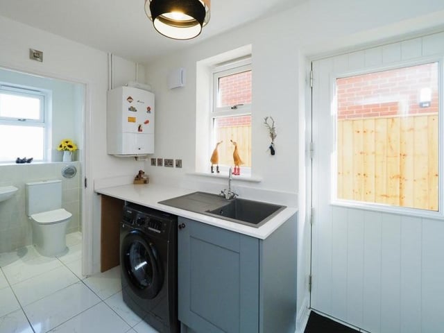 This utility room is a useful add-on to the kitchen, with space and plumbing for a washing machine. It also leads to the downstairs toilet (see background).
