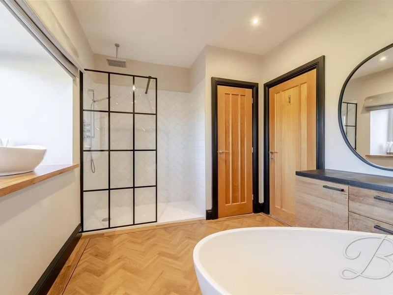 A stunning family bathroom featuring a luxurious four-piece suite that includes a low-flush WC, hand wash basin, shower cubicle, and a freestanding bath, blending style and functionality.