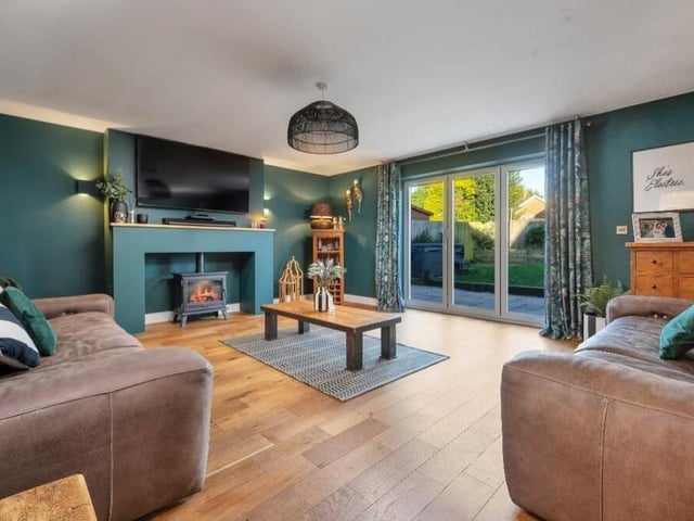 Our tour of the property couldn't begin in a more impressive room -- this beautifully presented lounge or living room, with feature fireplace and bi-folding doors opening on to the rear garden.
