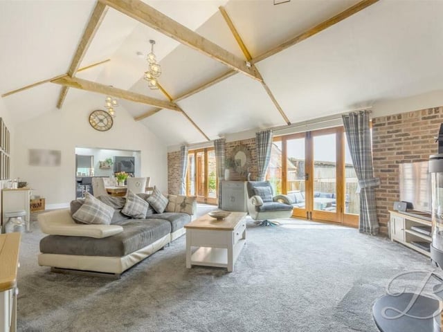 The best place to start our mini-tour of the Huthwaite barn conversion is the spacious, open-plan living room, which flows seamlessly into a dining area. Wooden ceiling beams are a feature, as are two sets of wooden French doors that allow natural light to fill the room and also lead to the garden.