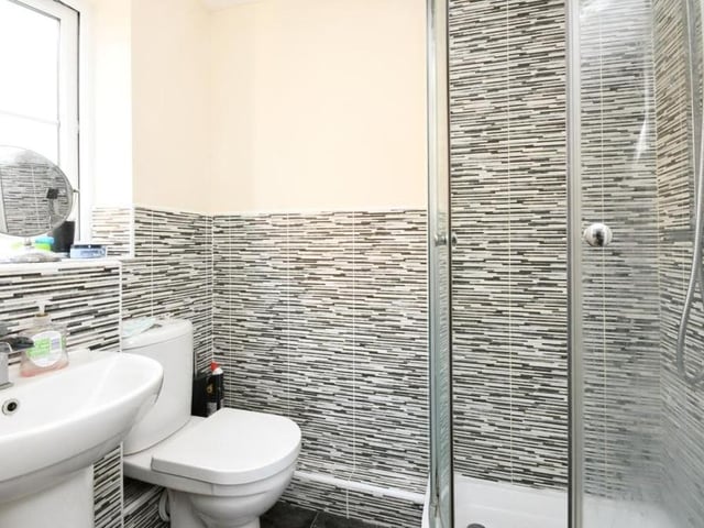 This en suite shower room belongs to the master bedroom. As well as a shower cubicle, it features a low-flush WC and wash hand basin,