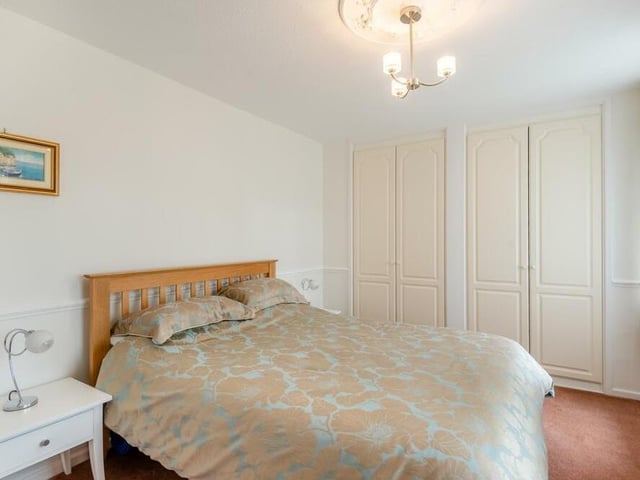 The second double bedroom at the £720,000 Mansfield property has two separate wardrobes with handing rails and shelves. It faces the front of the house.