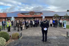 Coun Craig Whitby, with his back to the camera, leads the minute's silence at the Mansfield war memorial, behind Mansfield Civic Centre.