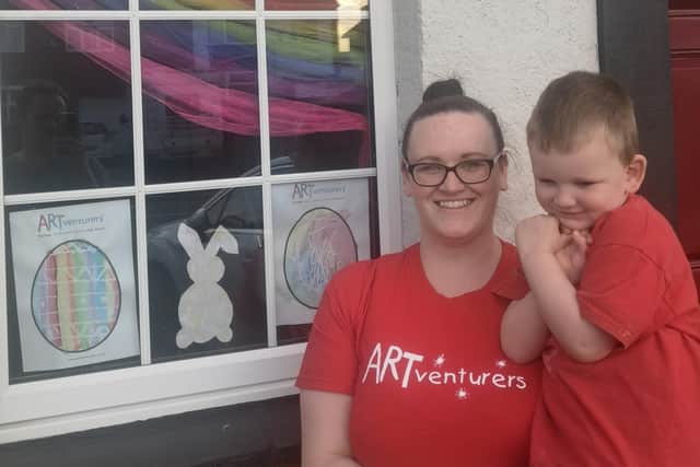 Stacey with her son Jensen, proudly displaying their Easter eggs in the window