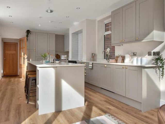 At the heart of the kitchen/diner is a large island with extensive quartz work surfaces, space for stools on one side, open shelving, pan drawers and bin storage. An inset one-and-a-half-bowl Belfast sink has a brushed, stainless steel mixer tap.