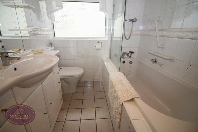 The family bathroom is a three-piece suite in white, comprising a bath with shower over, vanity sink unit, WC and heated towel-rail.
