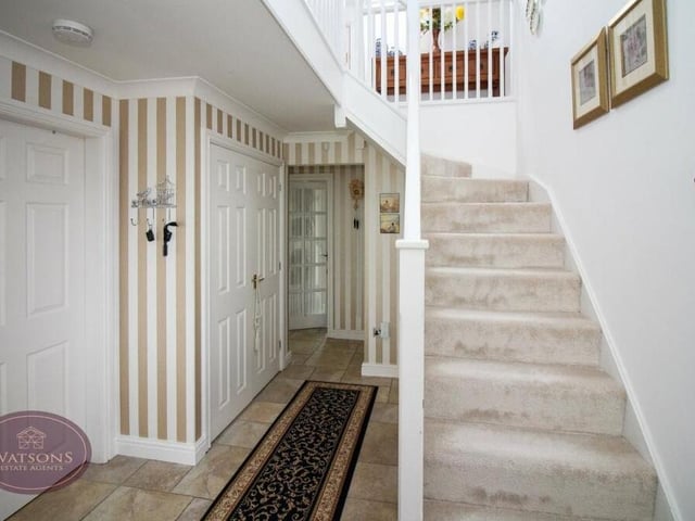 Time to check out the first floor now, so let's pass through the entrance hall, where the staircase is located.The space also includes a fitted cloak cupboard, ceiling spotlights and tiled flooring.