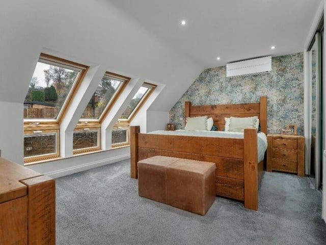 We're upstairs now, and here is the wonderful master bedroom, complete with a walk-in wardrobe, a further fitted wardrobe and access to an en suite shower room. A trio of feature double windows overlook the back garden.