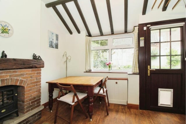 Next to the kitchen is this delightful dining area, distinguished by a feature fireplace. The door is one of many entrances to the property from outside.,