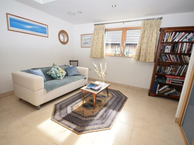 The ground floor of the Ravenshead property houses one of the five bedrooms, which is currently being used as a comfortable sitting room. It is a charming, flexible space with built-in wardrobes, feature circular windows, polished flooring and underfloor heating. It also has access to an en suite shower room.