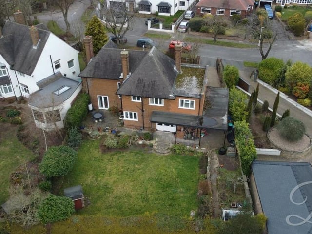 A closer aerial view, showing the size of the back garden, with the car port to the right and a patio seating area to the left.