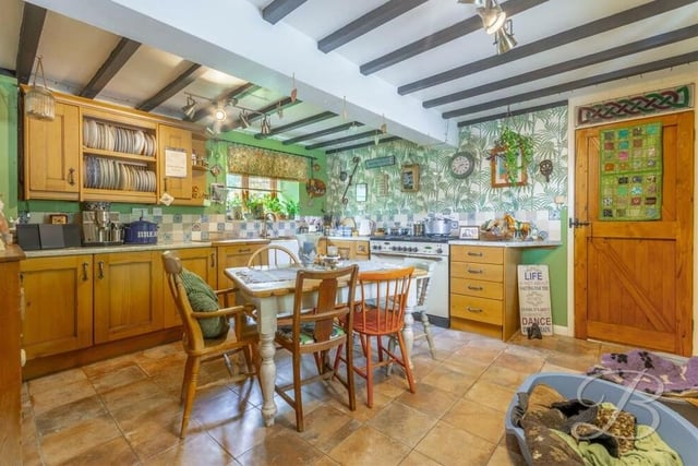 The kitchen has space and plumbing for a range of appliances, including a double oven. There are windows to the side of the house, while doors lead to a pantry and utility room.