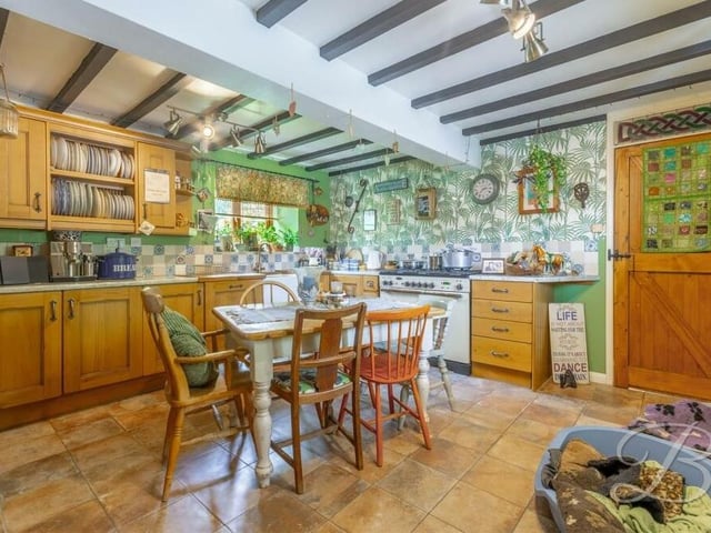 The kitchen has space and plumbing for a range of appliances, including a double oven. There are windows to the side of the house, while doors lead to a pantry and utility room.