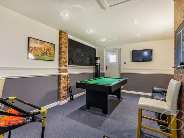 One half of the double garage has been transformed into a superb games room that includes a pool table, TV and seating.