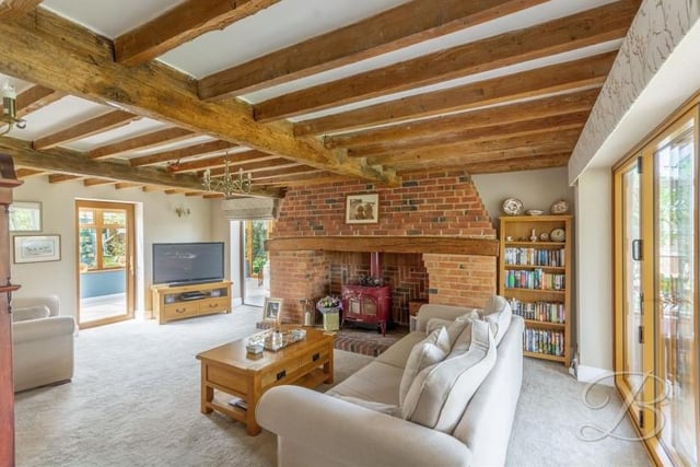 We start our tour of the Kirkby barn conversion in the delightful lounge, where retained original features include striking, exposed ceiling beams. The floor is carpeted and doors open into both of the property's conservatories.