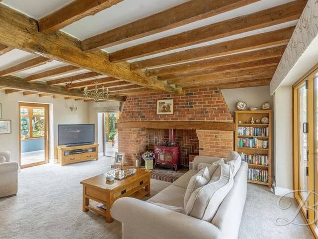 We start our tour of the Kirkby barn conversion in the delightful lounge, where retained original features include striking, exposed ceiling beams. The floor is carpeted and doors open into both of the property's conservatories.