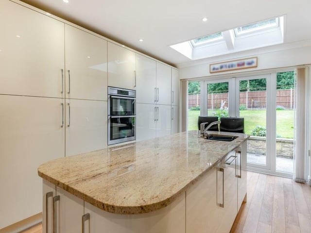 Integrated appliances in the kitchen include an AEG double oven, fridge and separate freezer, and a dishwasher. A central island includes an inset one-and-a-half bowl stainless steel sink with mixer tap, waste disposal and drainer built in to the worktop. There are also two Velux roof windows.